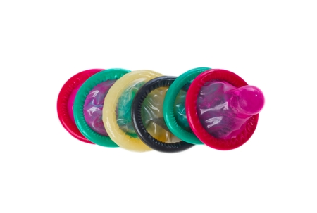 Multi colored condomsin a row isolated on whiteの写真素材