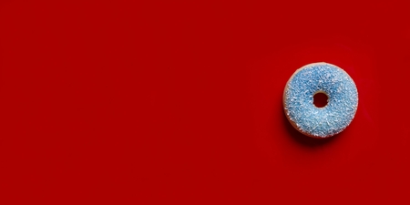Blue donut with grilled coconut isolated on a red background.の写真素材