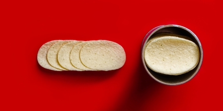 Close up of stacked potato chips - isolated on red background.の写真素材