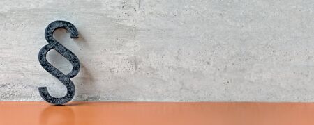 Paragraph / section sign in front of a concrete wall. Panoramic image with copyspace.の写真素材