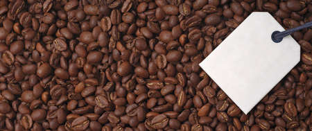 Top view of a bunch of roasted coffee beans. Panoramic image with label for your individual text.