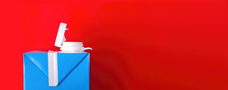Milk carton box on red background with copy space.. Recycling concept.の写真素材