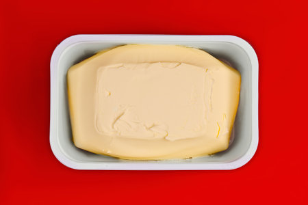 Just opened margarine box on red background.の写真素材