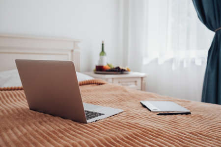 Laptop and Digital Tablet Laying on the Bed in Hotel Room, Freelance Concept, Workplace for Designer...