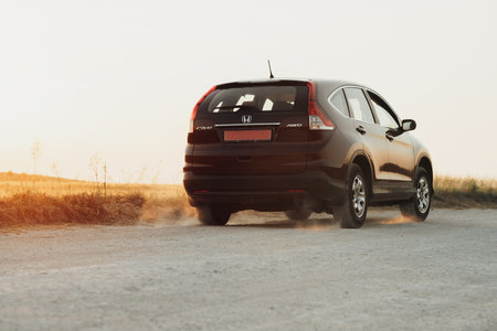 TERNOPIL, Ukraine - July 21 2021: Back View of Honda CR-V Riding on the Country Road at Sunset