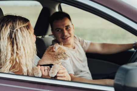 Happy Couple with Their Red Cat Enjoying Road Trip, Young Woman and Man Traveling by Car with Petの写真素材