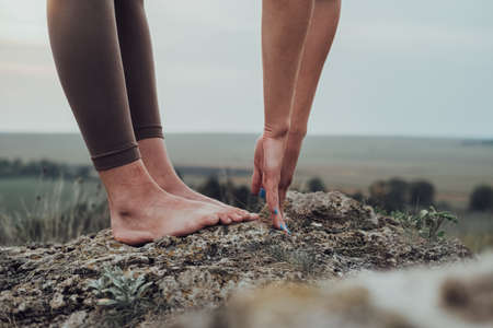Close Up of Unrecognisable Woman Doing Exercises on the Top of a Hill Outdoors