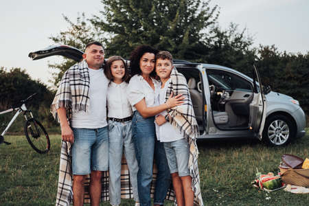 Four Members Family Having Picnic at Sunset, a Mother and Father with Two Teenage Children Enjoying Weekend Road Trip by Carの写真素材