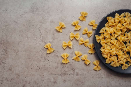 Handful of Pasta Laid Up on the Black Plate on the Table, Copy Space