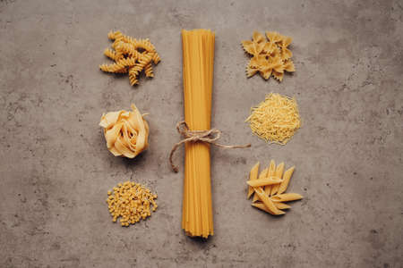 Flat Lay of Different Types of Pasta Laid Up Around Handful of Spaghetti on the Table