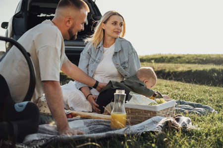 Young Family, Mom and Dad with Toddler Son Having Picnic Outdoors, Weekend Road Trip by Carの写真素材