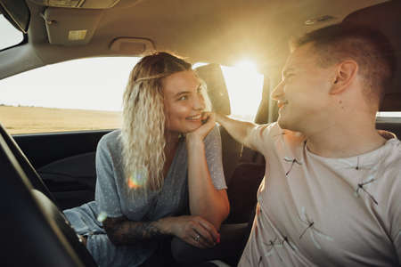 Happy Couple Enjoying Road Trip, Young Caucasian Woman and Man Having Fun Time While Traveling by Carの写真素材