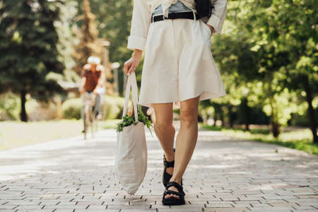Unrecognisable Woman Holding Shopping Eco Bag Outdoors While Walking in the Park at Sunny Summer Day
