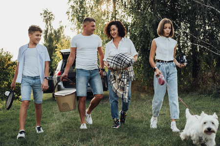 Four Members Family Having Picnic Outdoors at Sunset, Mother and Father with Two Teenage Children and Pet West Highland White Terrier Dog on the Road Trip by Carの写真素材
