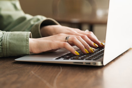 Close Up of Unrecognizable Woman Working on Laptop at a Cafe Table, Female Student Using Her...