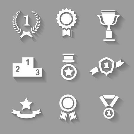 Set of white  award  success and victory icons with trophies  stars  cups  ribbons  rosettes  medals medallions  wreath and a podium on greyの写真素材