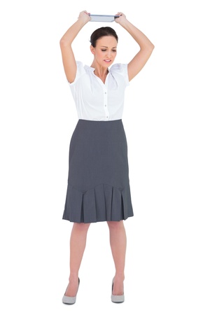 Angry businesswoman throwing her tablet pc while posing on white backgroundの写真素材