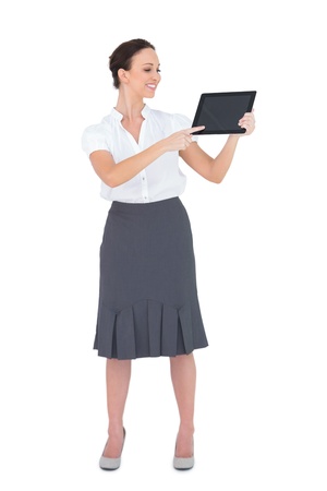 Cheerful businesswoman showing something on her tablet pc while posing on white backgroundの写真素材
