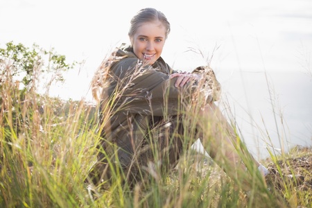 Woman sitting in grass looking at camera in the countrysideの写真素材