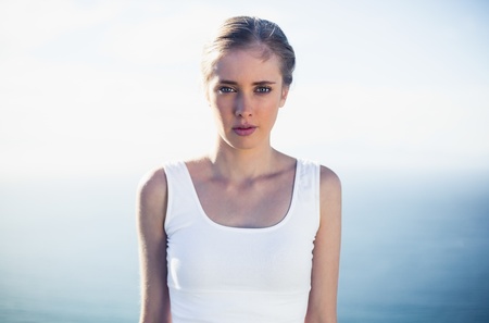 Beautiful woman looking at camera against blue backgroundの写真素材