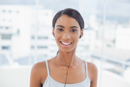 Cheerful pretty model listening to music in bright room at homeの写真素材