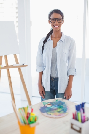 Smiling pretty artist posing in bright roomの写真素材