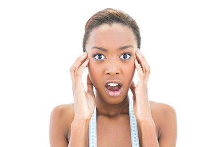 Shocked natural beauty with measuring tape over the neck on white backgroundの写真素材