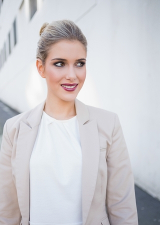 Smiling attractive businesswoman posing outdoors on urban backgroundの写真素材
