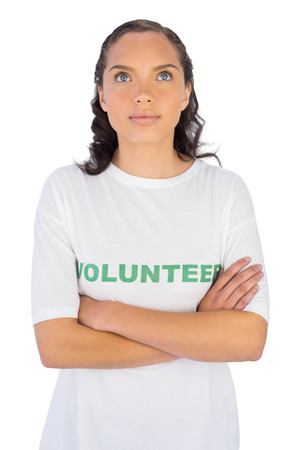 Brunette wearing volunteer tshirt with arms crossed against white の写真素材