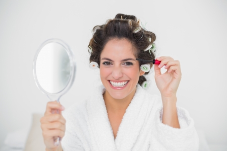 Cheerful natural brunette holding mascara in bedroomの写真素材