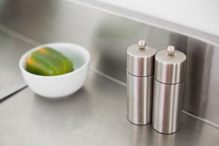 Salt and pepper on a chrome counter in the kitchen at homeの写真素材