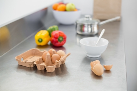 Vegetables and eggs lying on the work surface of a kitchen