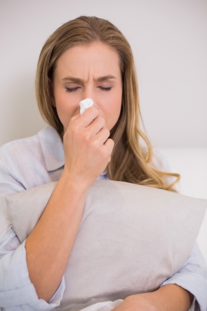 Devastated casual blonde sitting on couch crying in living roomの写真素材