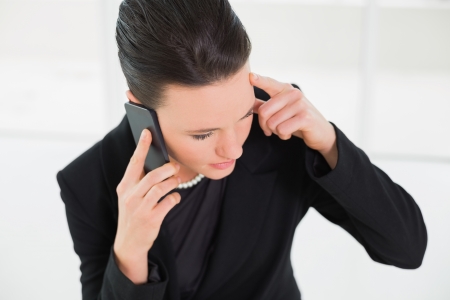 Close up of a serious elegant businesswoman using cellphoneの写真素材