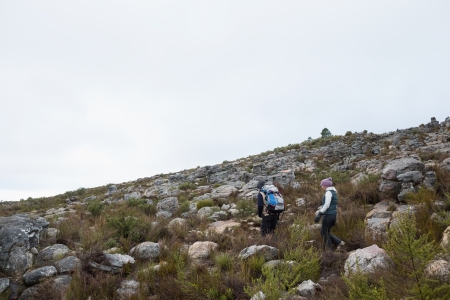 Full length side view of a couple walking through rocky landscape against clear skyの写真素材