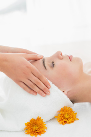 Side view of hands massaging a beautiful womans face at beauty spaの写真素材