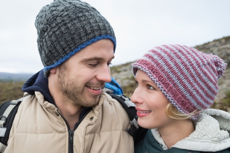 Smiling fit loving couple on a hike in the countryside against clear skyの写真素材