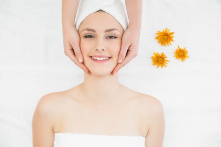 Close up of hands massaging a beautiful womans face at beauty spaの写真素材