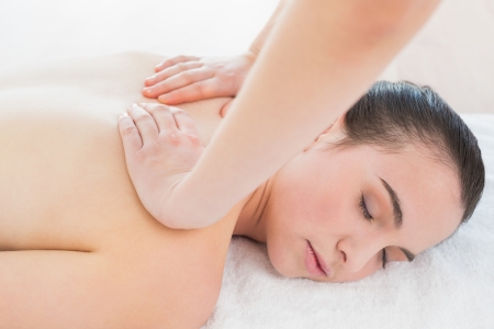 Close up of a beautiful woman enjoying back massage at beauty spaの写真素材