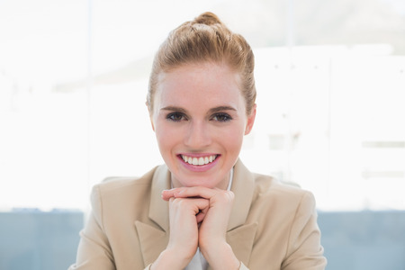 Close up portrait of an elegant businesswoman smiling in a bright officeの写真素材