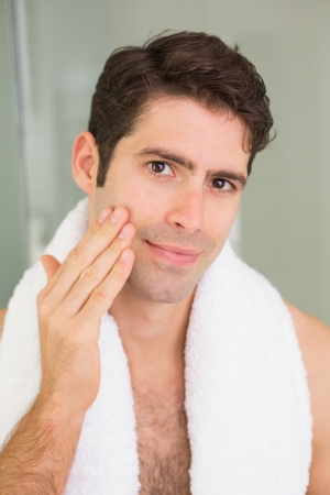 Close up portrait of a handsome young man touching his faceの写真素材