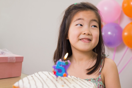 Close-up of a cute little girl with cake at her birthday party