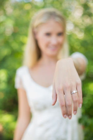 Blonde bride showing her diamond ring in the countrysideの写真素材