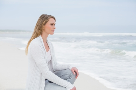 Full length side view of a casual young woman relaxing at the beachの写真素材