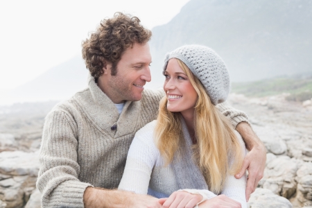 Happy romantic young couple sitting together on a rocky landscapeの写真素材