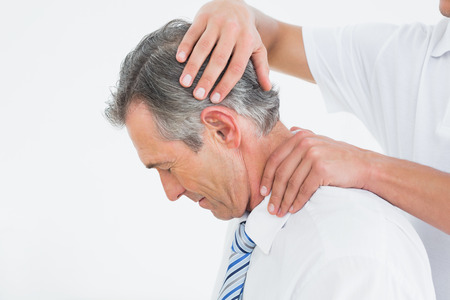 Side view of a chiropractor doing neck adjustmentの写真素材