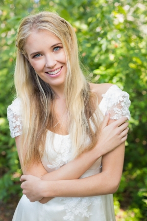 Blonde pretty bride smiling at camera in the countrysideの写真素材