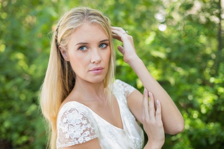 Content beautiful bride touching her hair in the countrysideの写真素材