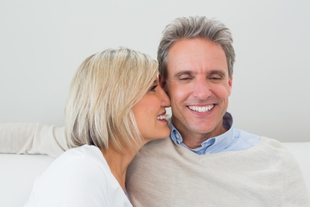 Close-up of a happy loving man and woman sitting in living room at homeの写真素材