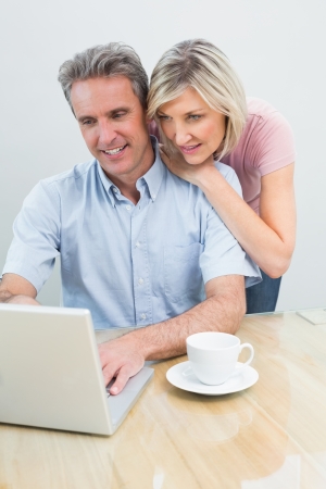 Concentrated content casual couple using laptop at homeの写真素材
